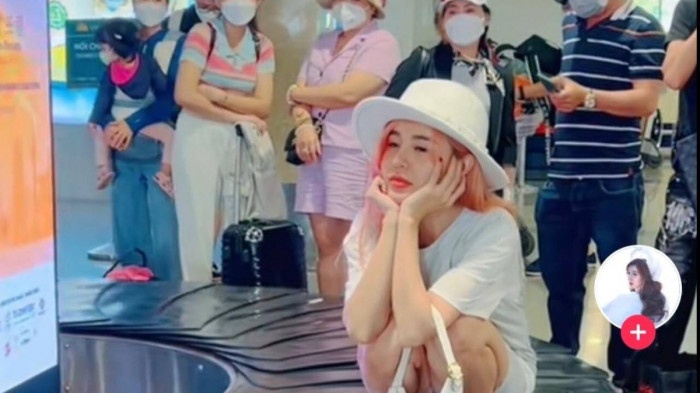 Co gai ngoi tren bang chuyen hanh ly tai san bay co the bi cam bay hinh anh