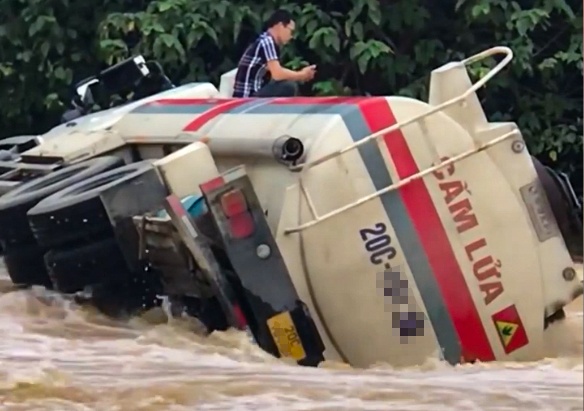 Xe bon lat giua dong nuoc lu, tai xe bat luc ngoi cho giai cuu hinh anh