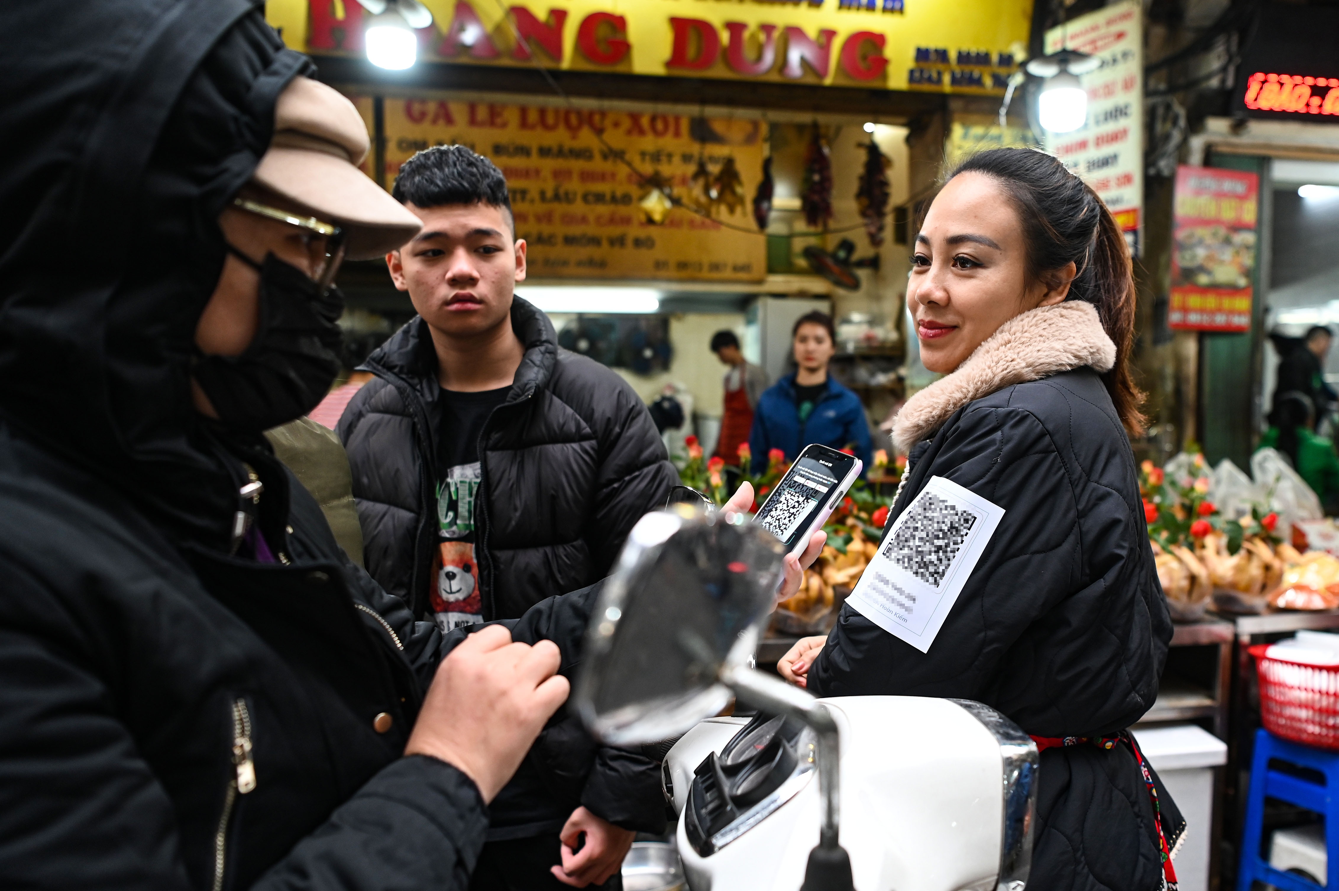 Dan ma QR len nguoi vi qua dong khach di cho Tet muon chuyen khoan hinh anh