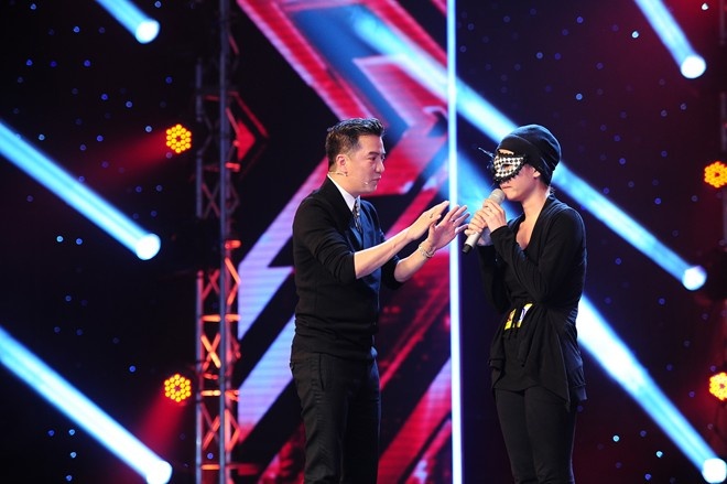 Anh Thúy dùng mặt nạ che mặt xuất hiện trên sân khấu X Factor.