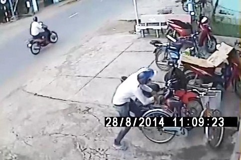Tên trộm bẻ khóa và dắt xe đi rất nhanh chóng.