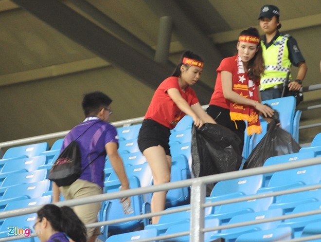Cổ động viên Việt Nam dọn rác sau khi trận đấu U23 Việt Nam gặp U23 Malaysia trên sân Bishan (Singapore). Ảnh: Tùng Lê.