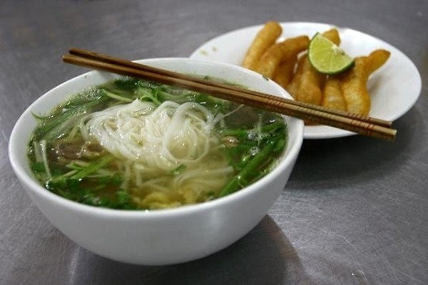 Khách thắc mắc chuyện hai bát phở giá 800.000 đồng, chủ quán đáp lại bằng cách chém con dao xuống mặt bàn và quát “không nói nhiều”. Ảnh: Khương Xuân - Báo Tuổi Trẻ. 