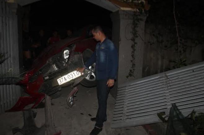 Chiếc xe ôtô mắc kẹt ngay trước cổng nhà ông Giảng và bị hư hỏng nặng.