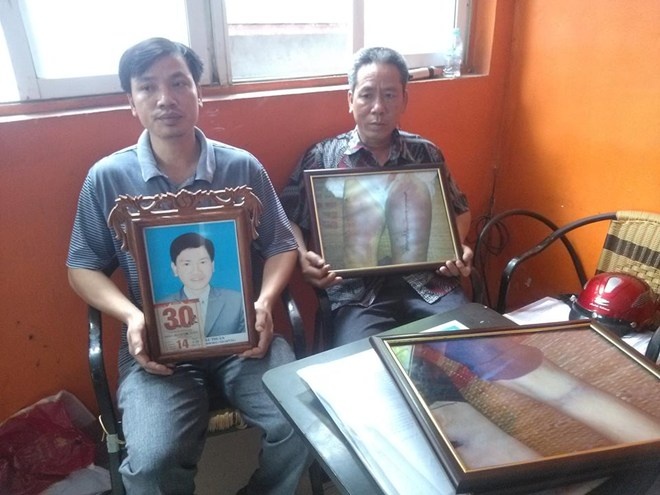 Người thân của ông Thuận bên di ảnh của nạn nhân. Ảnh: Lao động.
