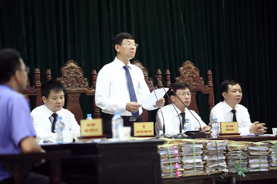 Chủ tọa phiên tòa Nguyễn Hữu Chính đọc quyết định khởi tố 2 vụ án Lừa đảo chiếm đoạt tài sản và Kinh doanh trái phép. Ảnh: Hoàng Quân.