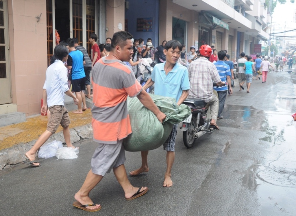 Nhiều hộ dân buôn bán lo sợ vụ hỏa hoạn lây lan đến nhanh huy động nhau di dời số hàng của mình đến khu vực an toàn.