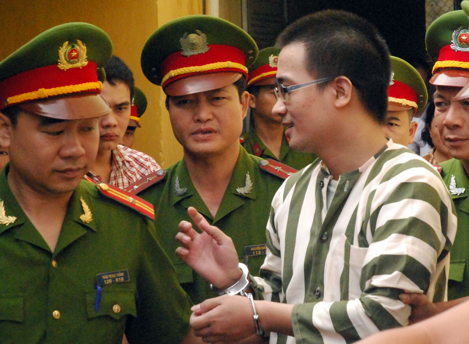 Nụ cười hiếm hoi của Nguyễn Đức Nghĩa khi gặp người thân sau phiên xét xử. Ảnh: Hà Anh.