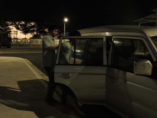 Cơ quan công an dẫn Điểm ra xe để vào trại tạm giam.