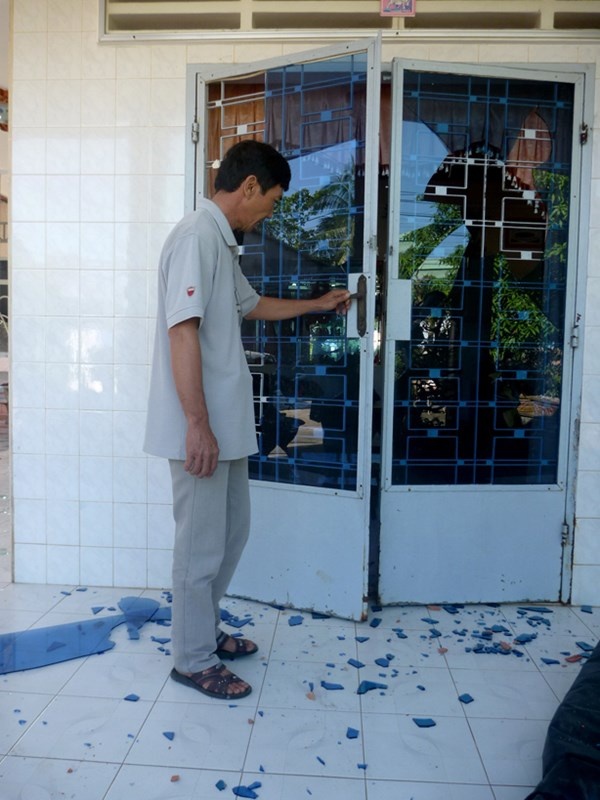 Ông Nguyễn Chí Đức bên cánh cửa bị nhóm côn đồ xông vào nhà đập phá vào tối 19/12.