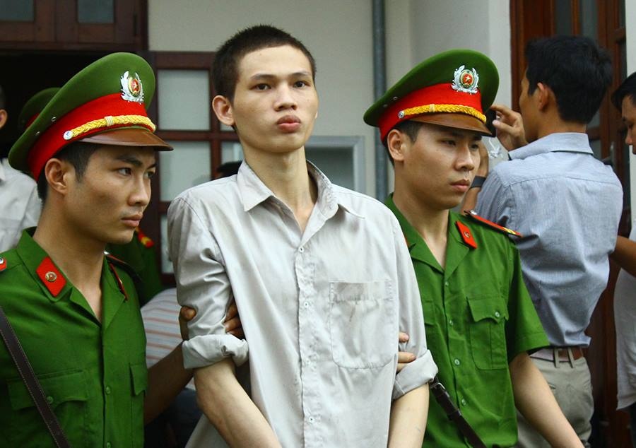Sau phiên xử, cảnh sát dẫn giải Phùng Mạnh Tuấn ra xe thùng. Ảnh: M.Đ.
