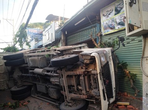 Chiếc xe tông gãy hai cây xanh, làm hỏng nhà và khiến một bà cụ bị thương.