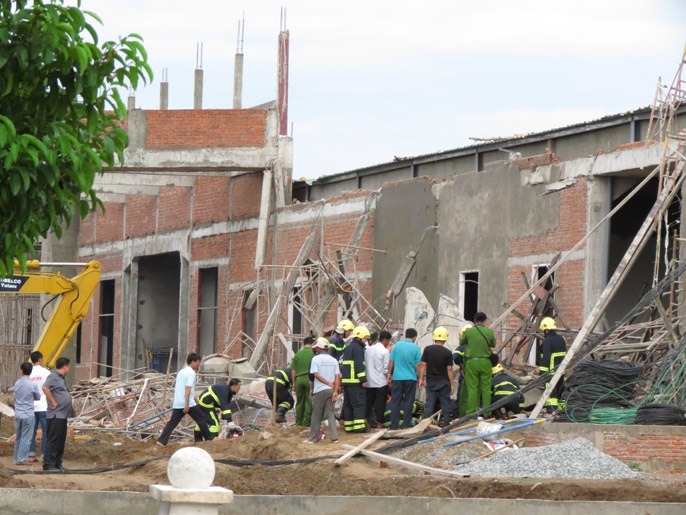 Cận cảnh hiện trường lực lượng cứu hộ đang đưa người ra khói đống đổ nát.