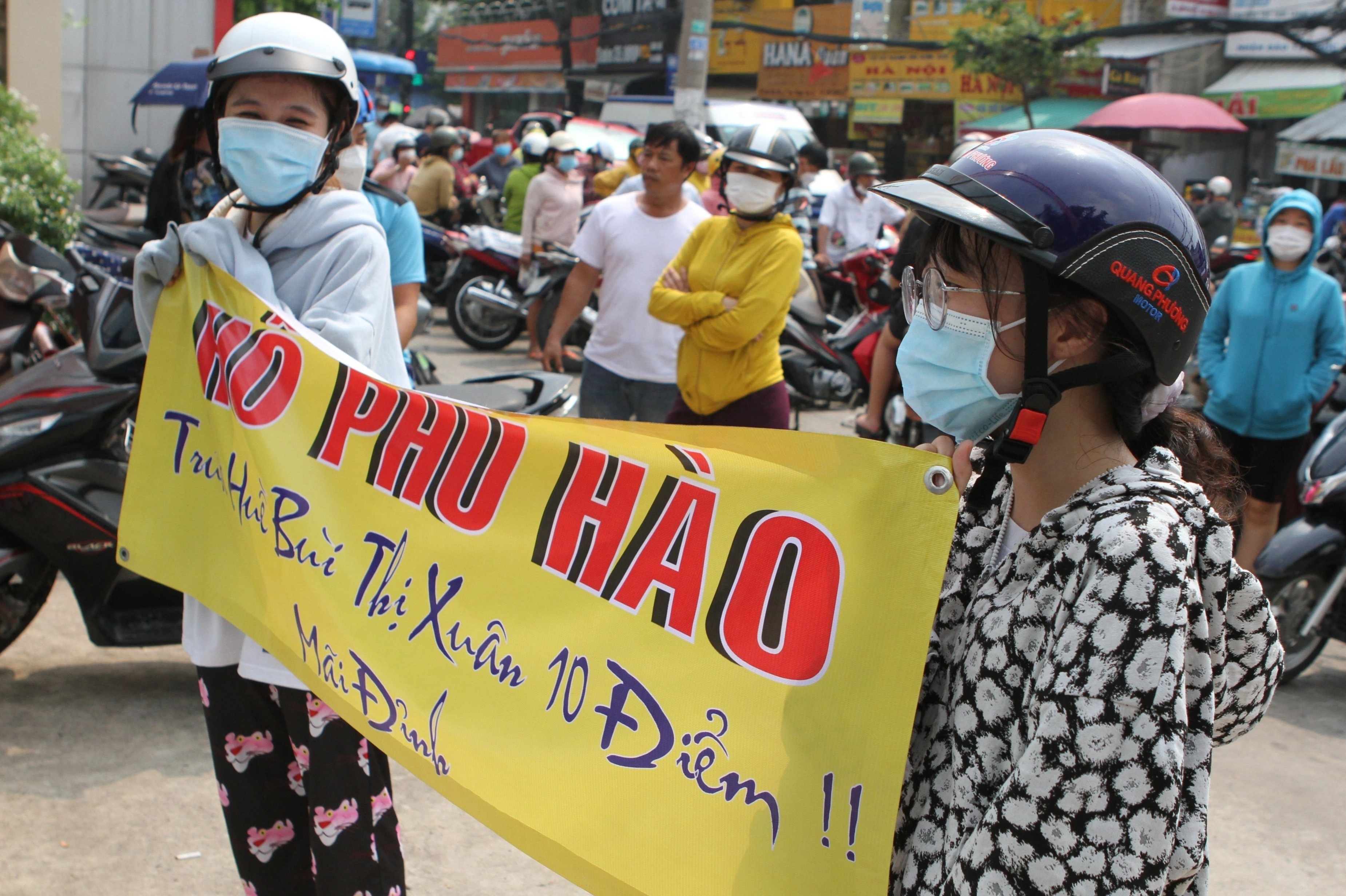 Hai chi gai mang theo bang ron co vu em trai thi vao lop 10 o TP.HCM hinh anh