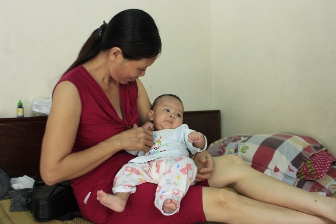 Bé gái 3 tháng tuổi trong vòng tay bà Mai. Ảnh: Phương Chi