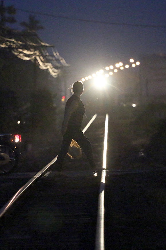 Còi tàu inh ỏi và ánh đèn pha sáng chói nhưng người phụ nữ này vẫn thản nhiên băng qua đường ray