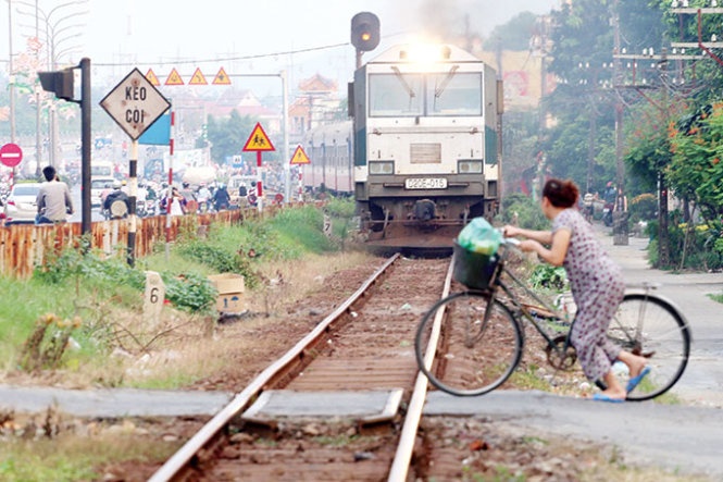 Đây là cảnh thường ngày ở các đường ngang không rào chắn tại phường An Hòa (TP Huế). Trong ảnh: một phụ nữ cố lao qua đường ray vào 17g ngày 19-3, khi tàu SE3 liên tục hú còi và chỉ cách đường ngang chừng 10m