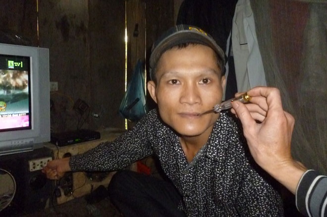 Tuân ngậm tuốctơvít vào miệng cắm vào ổ điện, bút thử đèn báo sáng.