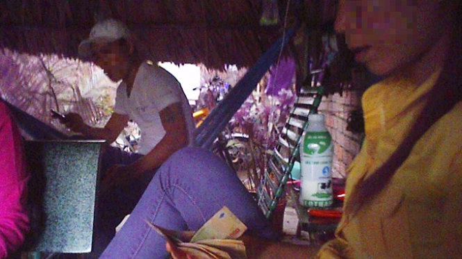 Vợ ông Quân đếm nhận số tiền “chuộc” chị D. (quê Thanh Hóa) ra khỏi quán cà phê Anh Thư