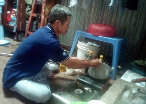 Bán báo về, lão vào bếp nấu cơm trưa cho các cháu.