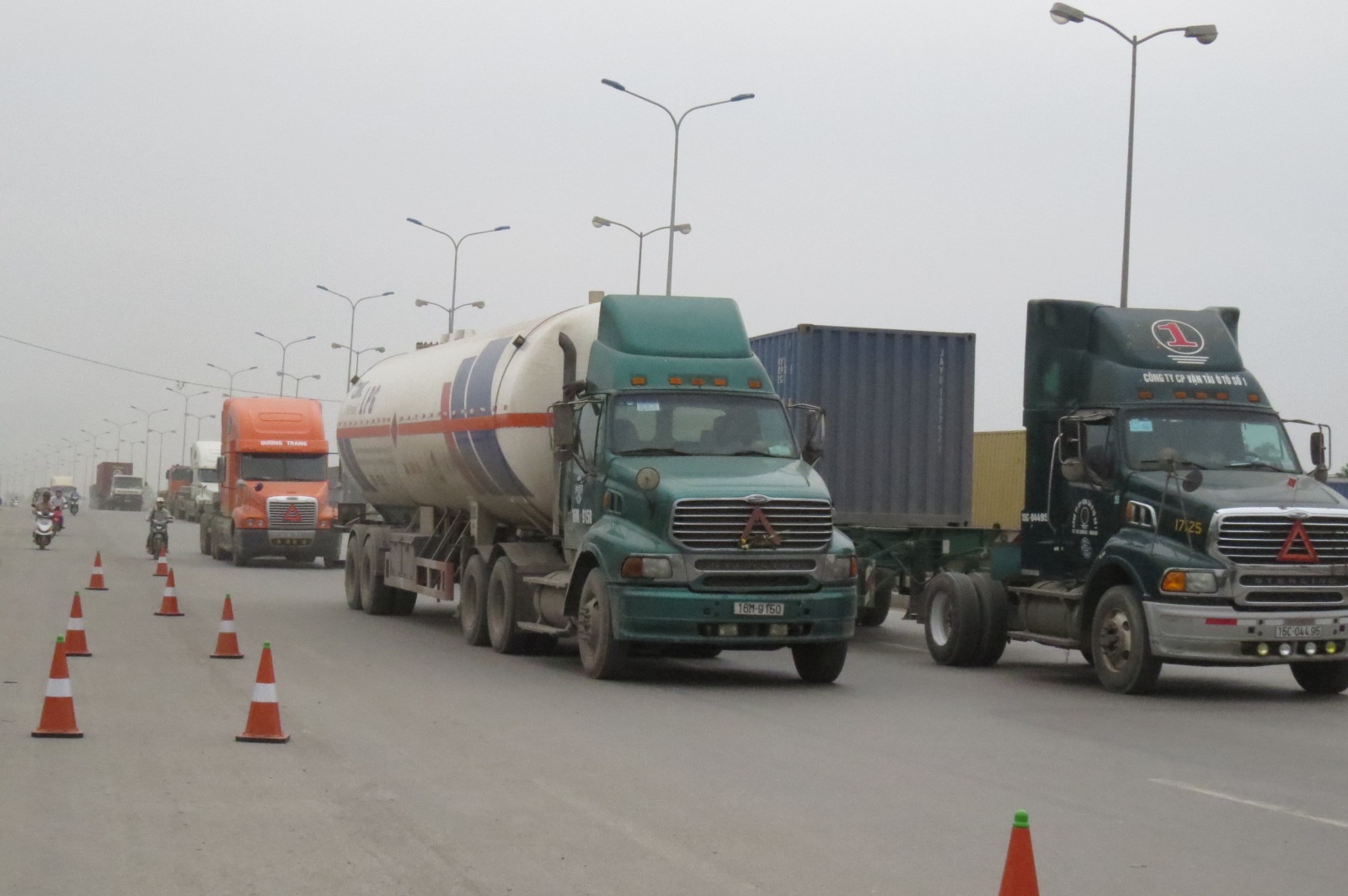 Tranh thủ lúc lực lượng chức năng bận xử lý vi phạm, nườm nượp xe tải trọng lớn nối đuôi nhau qua đoạn đường đặt trạm kiểm soát