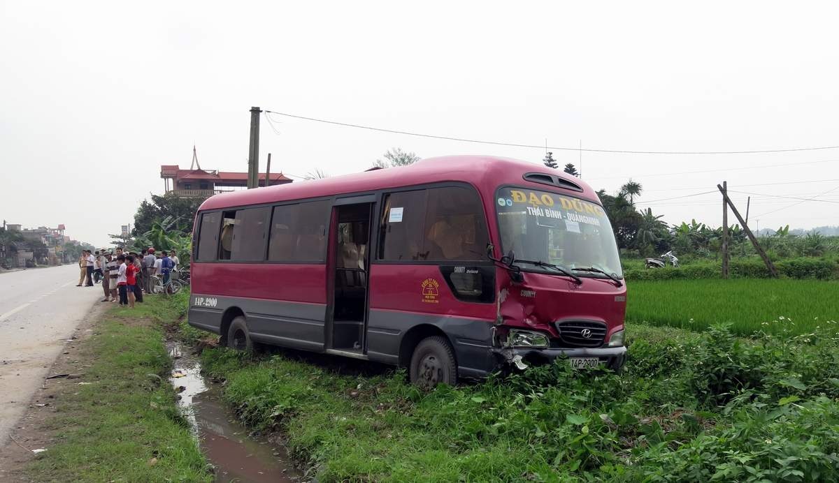 Xe cho 20 khach lao xuong ranh nuoc ven duong hinh anh