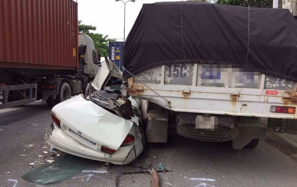 Oto bien xanh bep rum vi bi kep giua xe container va xe tai hinh anh