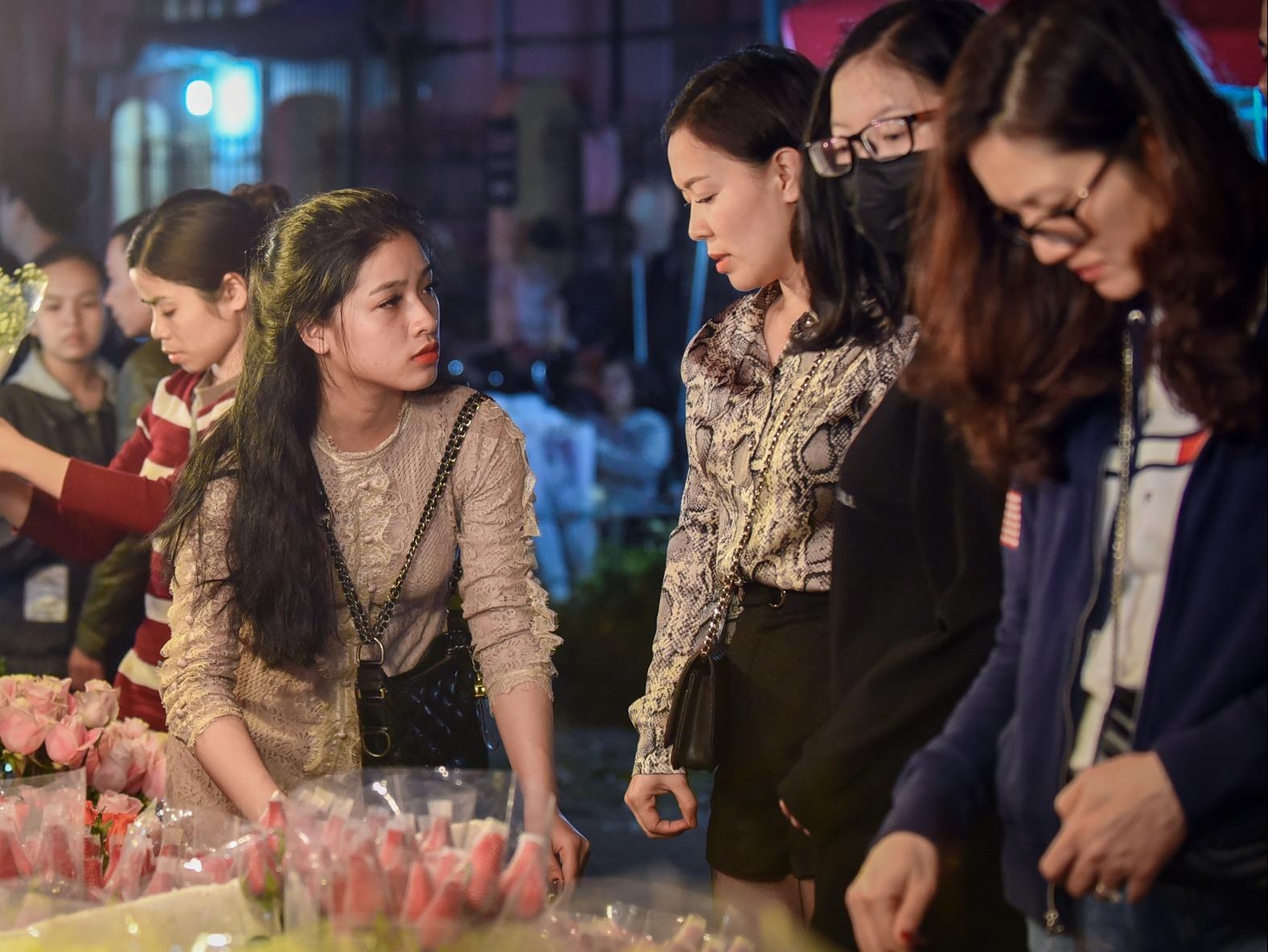 Nguoi dan un un di cho hoa trong dem cuoi hinh anh