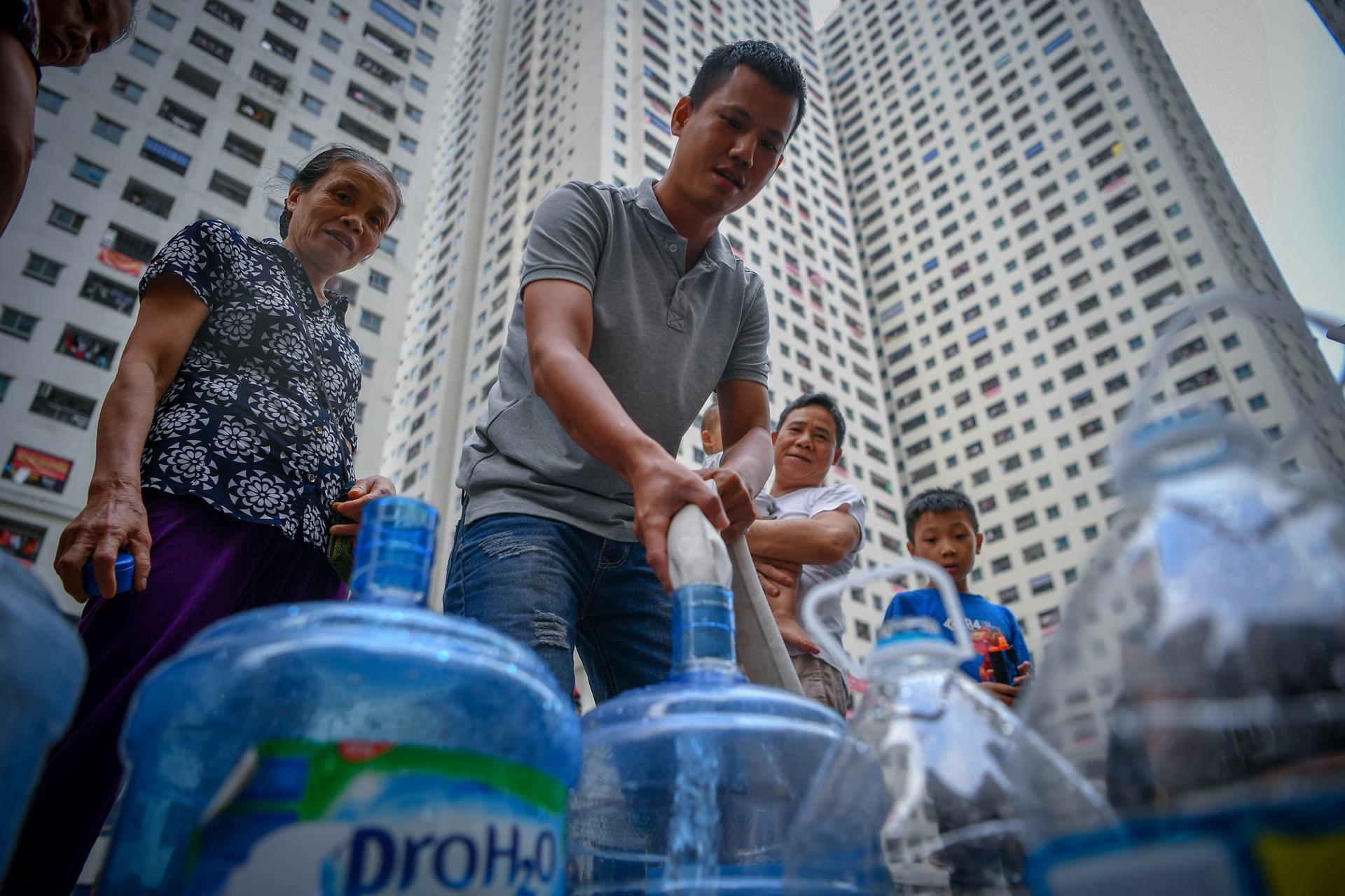 Nguoi dan mang xo, chau xep hang lay nuoc sach hinh anh