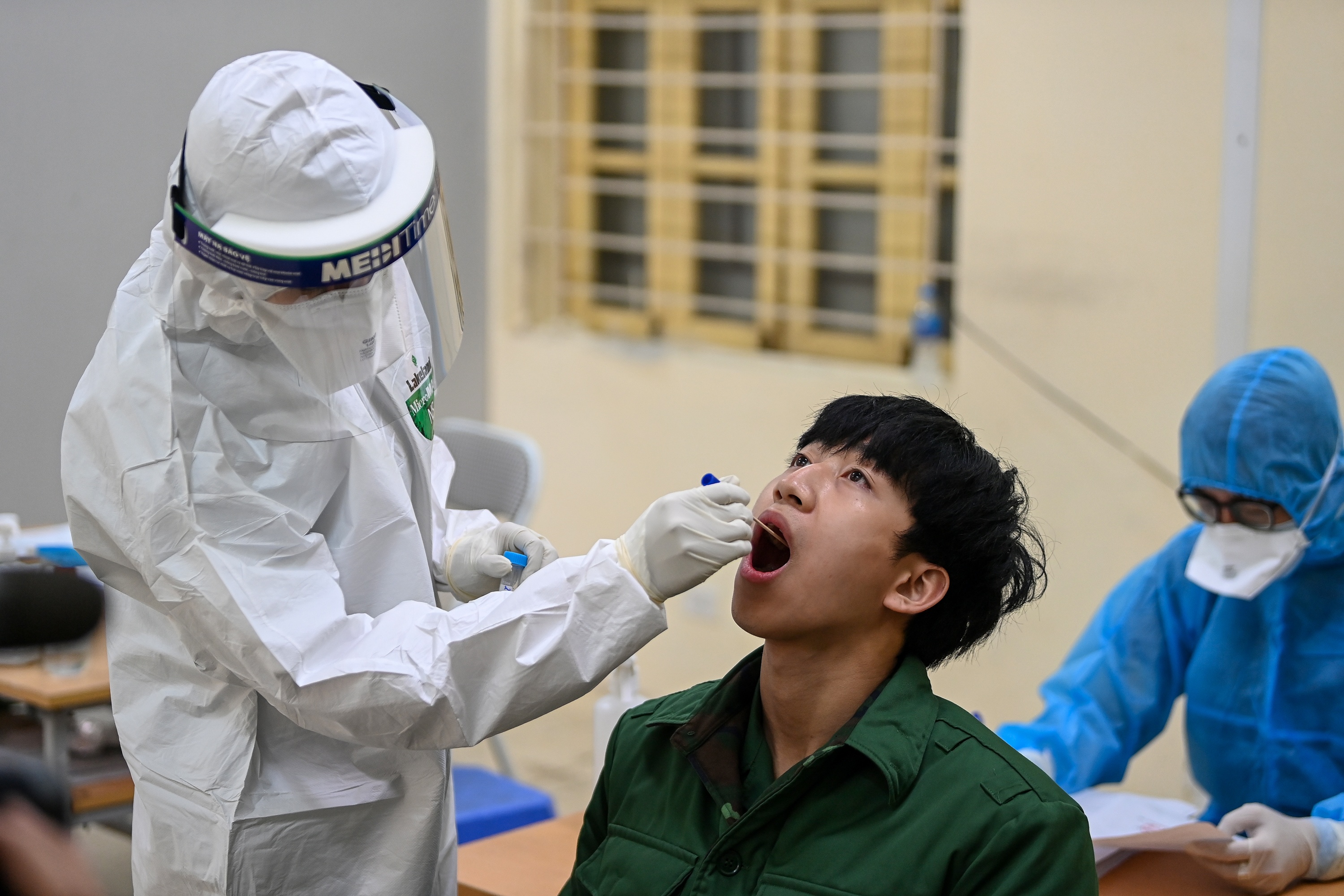 Thanh nien Ha Noi di xet nghiem SARS-CoV-2 truoc ngay nhap ngu hinh anh