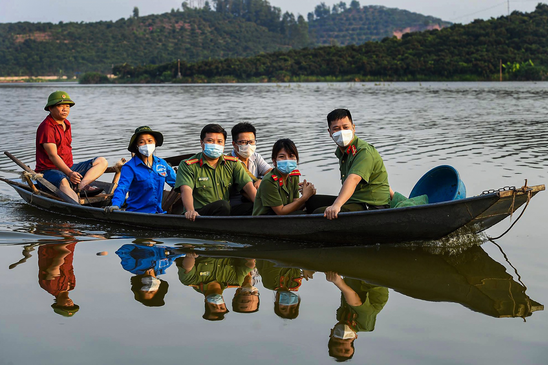 Cong an di thuyen thu hoach vai, giup nong dan vung dich hinh anh