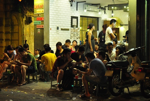 Tại một quán ăn vặt phong cách Thái trên phố Nhà Chung, khách xếp hàng và ngồi tràn ra cả vỉa hè.