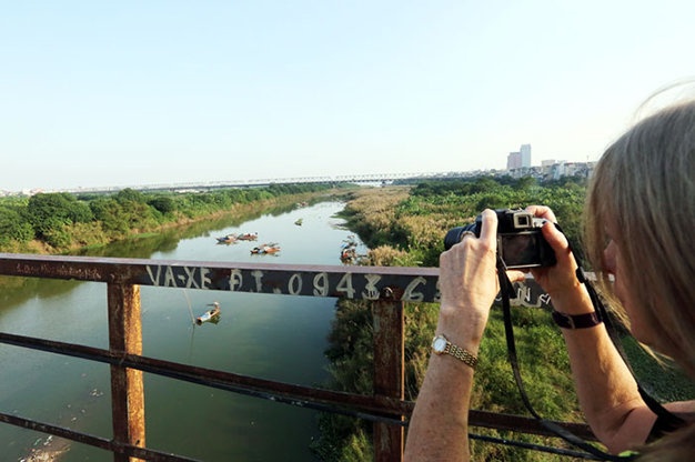 Vẻ đẹp thơ mộng của cánh đồng hoa cỏ lau hai bên bờ sông Hồng thu hút du khách chụp ảnh tại khu vực cầu Long Biên, Hà Nội.