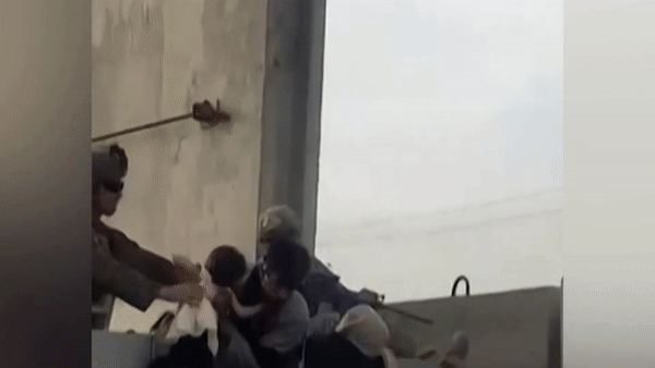 Be gai duoc be qua buc tuong de vao san bay Kabul hinh anh