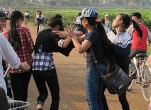 Nu sinh danh ban ngay truoc cong truong hinh anh