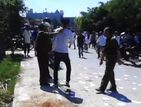 Lực lượng Công an xã -bảo vệ khu vực thi yêu cầu một thí sính nhặt “phao” thi. (Ảnh cắt từ clip)