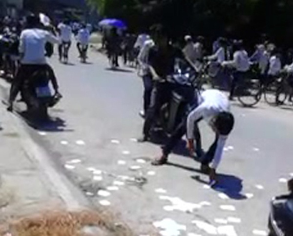 Nam thí sính nhặt “phao” thi sau khi bị lực lượng bảo vệ khu vực thi yêu cầu. (Ảnh cắt từ clip)