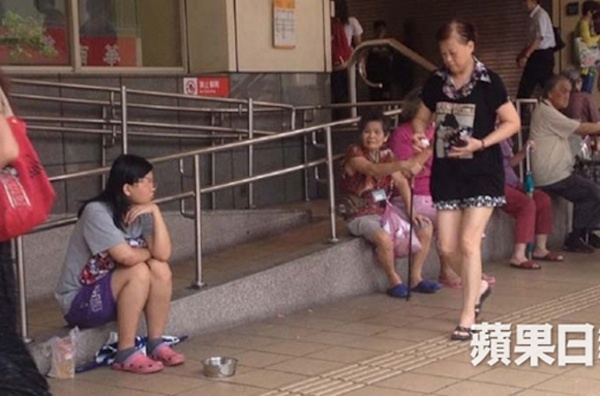 Su ăn mặc chỉnh tề ngồi bên chiếc bát ăn xin của mình.