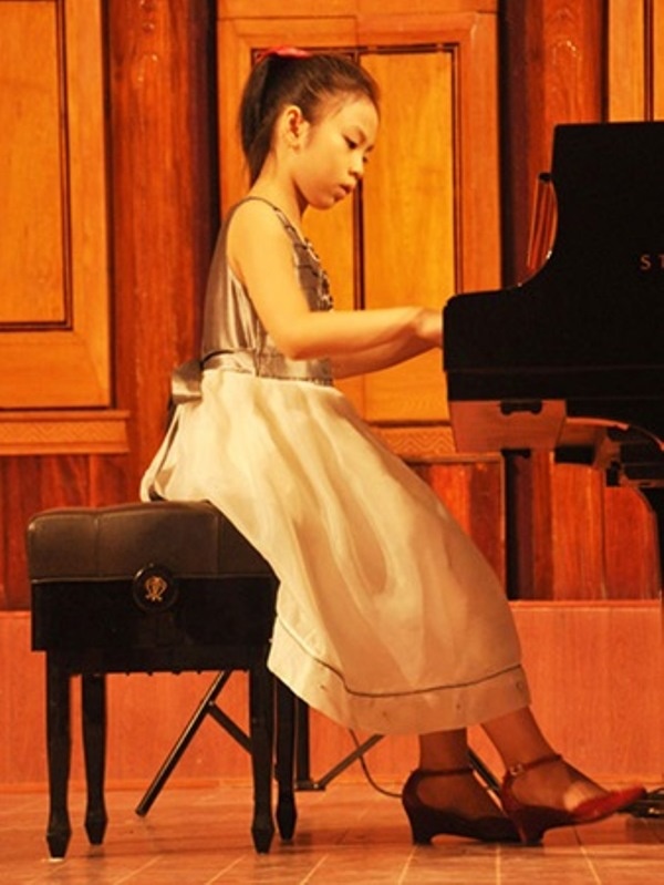 Hình ảnh Bạch Anh đang say sưa chơi đàn.