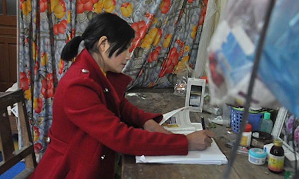 Chị Xuân đang soạn bài giảng trong căn phòng nhỏ của gia đình. 