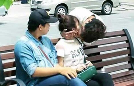 Một cặp đôi đang ngồi tâm sự trên ghế nơi công viên cũng bị người lạ bất ngờ “bẻ cổ” hôn môi cô gái. (Ảnh cắt từ clip)
