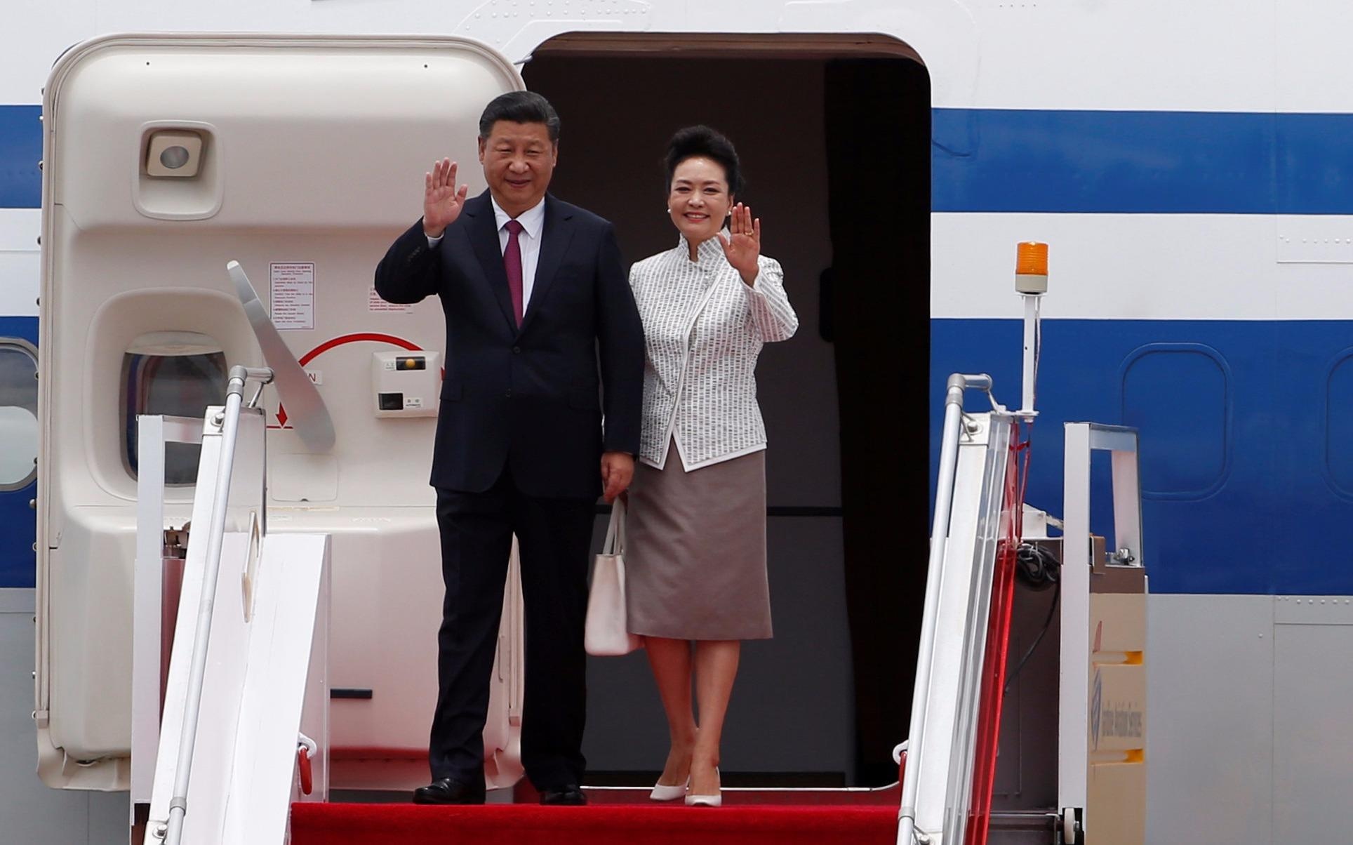 Ong Tap Can Binh cung phu nhan tuoi cuoi o san bay Hong Kong hinh anh