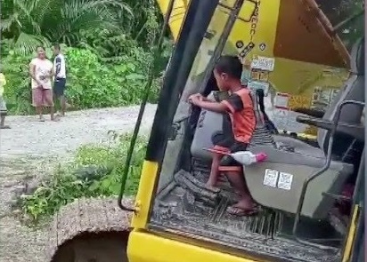 Cau be 5 tuoi dieu khien may xuc co lon o Indonesia hinh anh