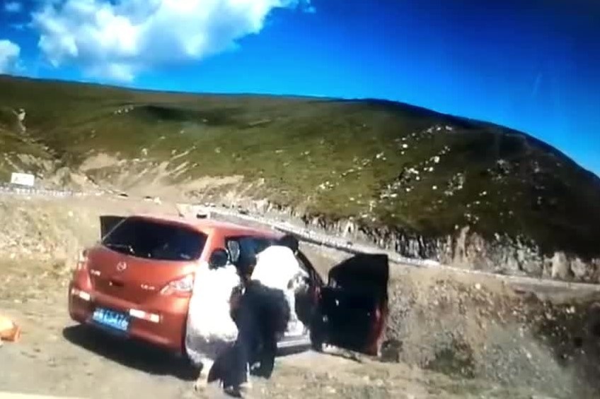 Hanh khach bi ket trong chiec xe dang troi xuong vuc o Trung Quoc hinh anh