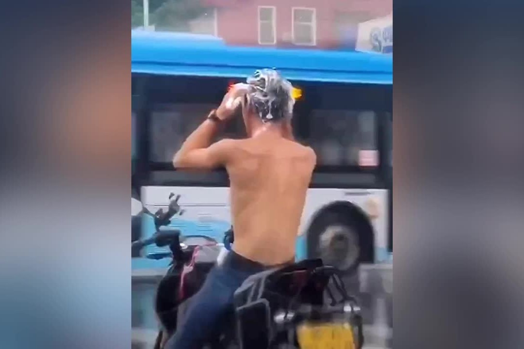 Nguoi dan ong goi dau khi dang di xe may o Trung Quoc hinh anh