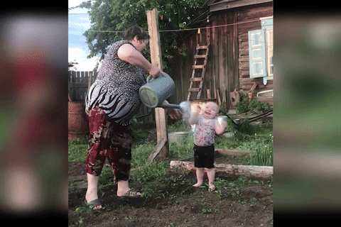 Be trai 18 thang tuoi thich thu khi duoc tuoi nuoc len nguoi hinh anh