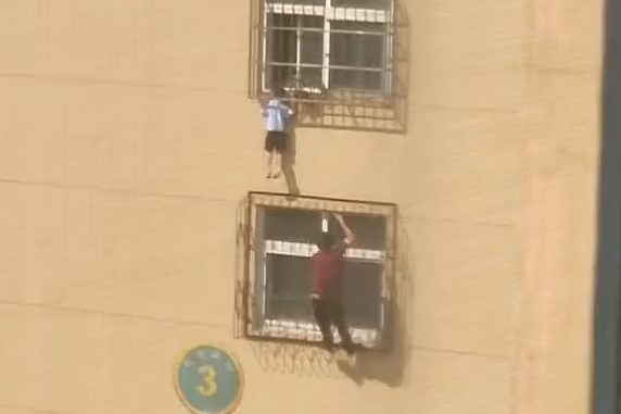 Nguoi dan ong treo len tang 4, cuu be trai bi ket dau o cua so hinh anh