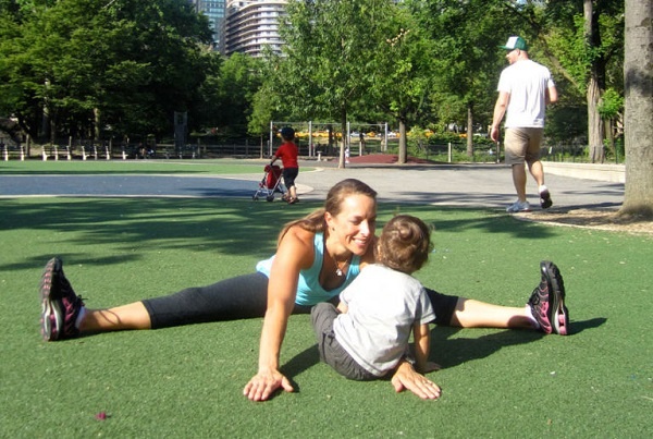 Động tác 3: Duỗi chân thành hình chữ V, đặt bé ngồi phía trước. Vươn dài tay, duỗi người tiến về phía bé và vui đùa với bé.