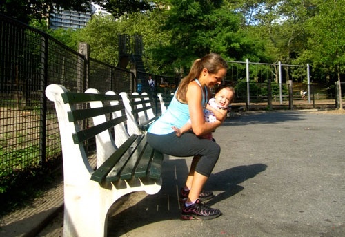 Động tác 5: Bế bé, ngồi từ từ xuống chiếc ghế dài theo tư thế ngồi xổm. Dang rộng hai chân, rồi co bóp cơ bụng rồi tiếp tục từ từ đứng lên. Thực hiện nhiều lần.