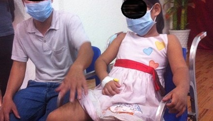 Bé V. và người nhà. Ảnh: Quốc Ngọc